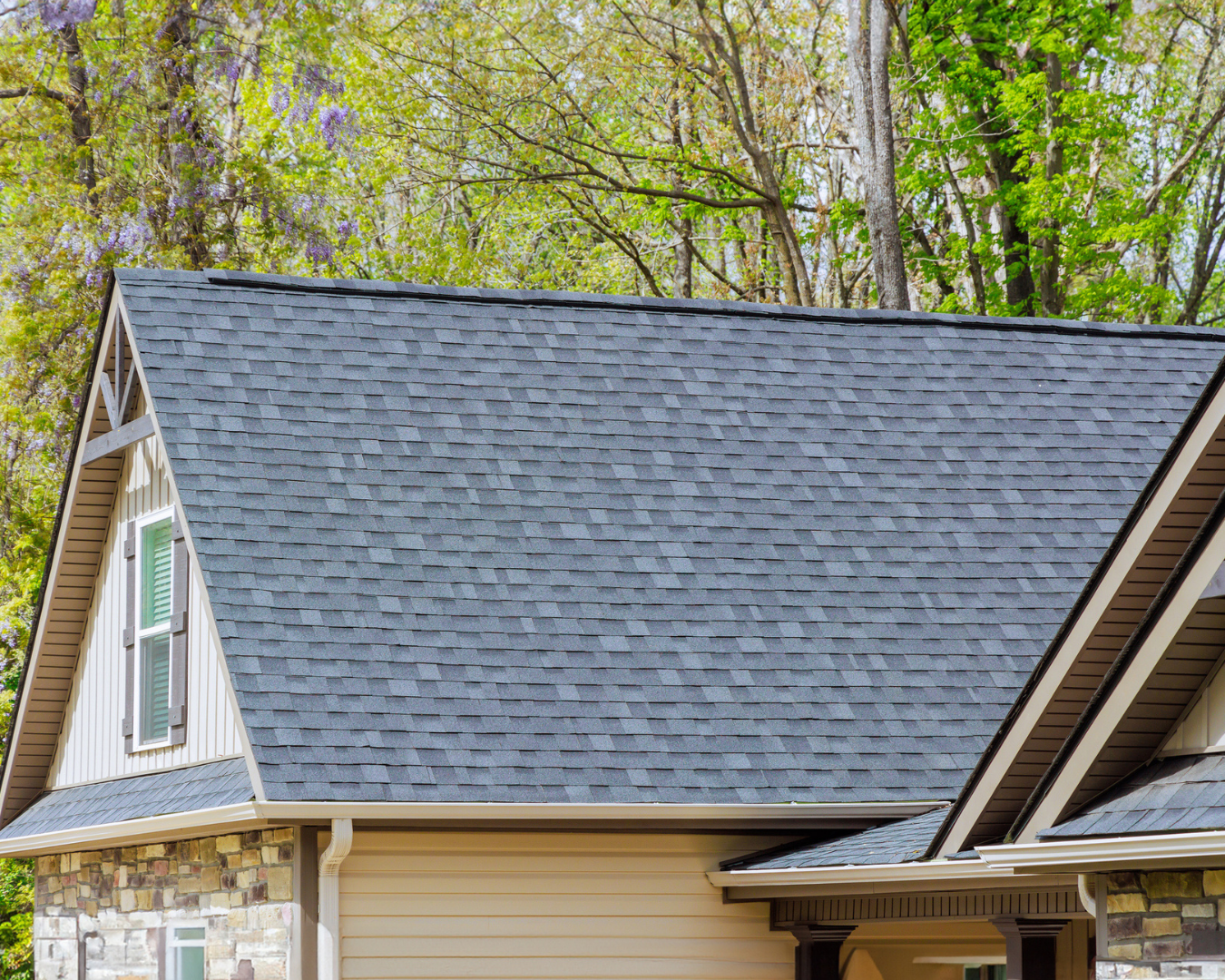 Beautiful residential home with new asphalt shingles on a bright, sunny day.